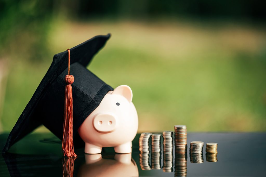 piggy bank With Graduation Cap on black glass floor,Money saving concept.
